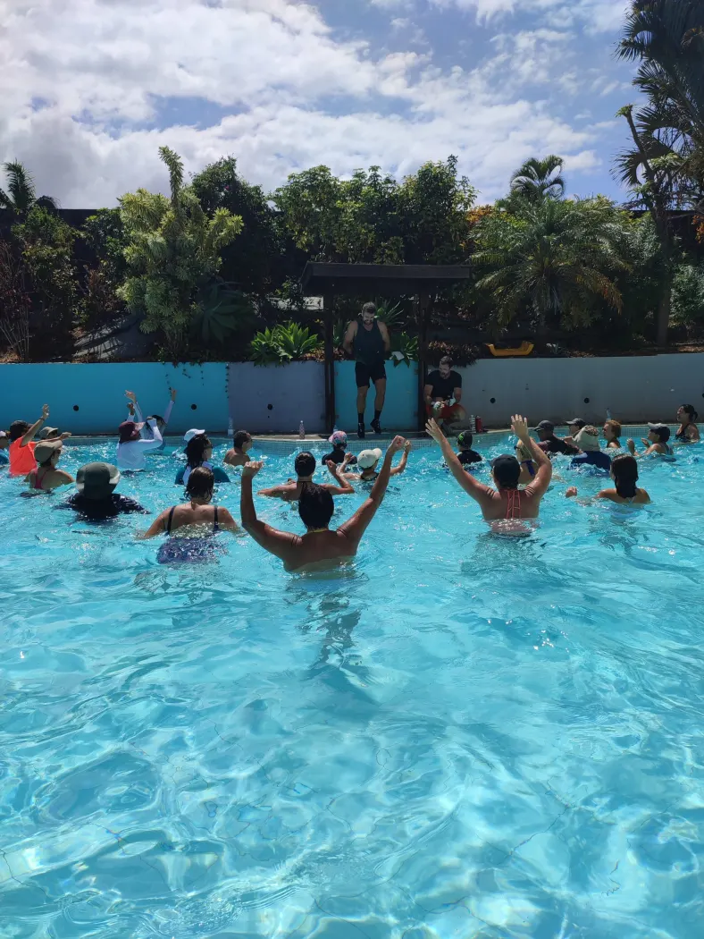 Participants au cours Aqua Fit, bras levés, pendant une séance cardio en musique