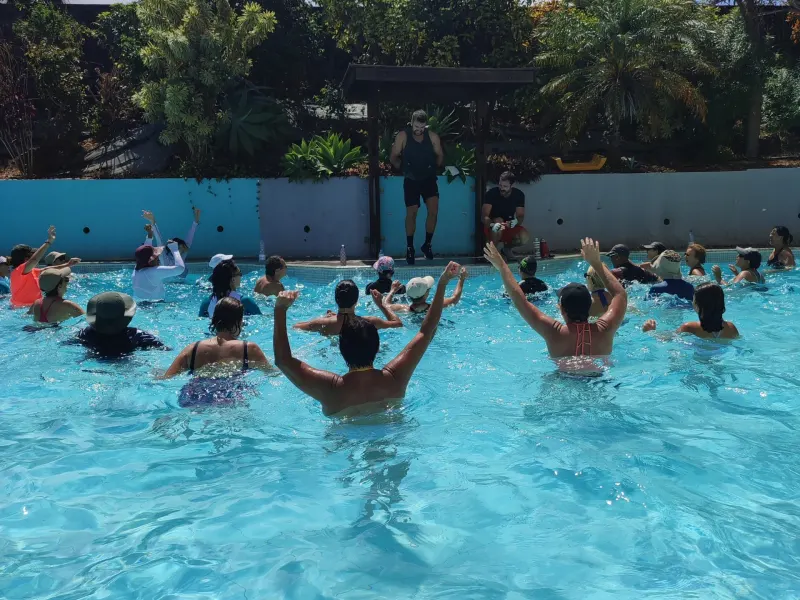 Participants au cours Aqua Fit, bras levés, pendant une séance cardio en musique