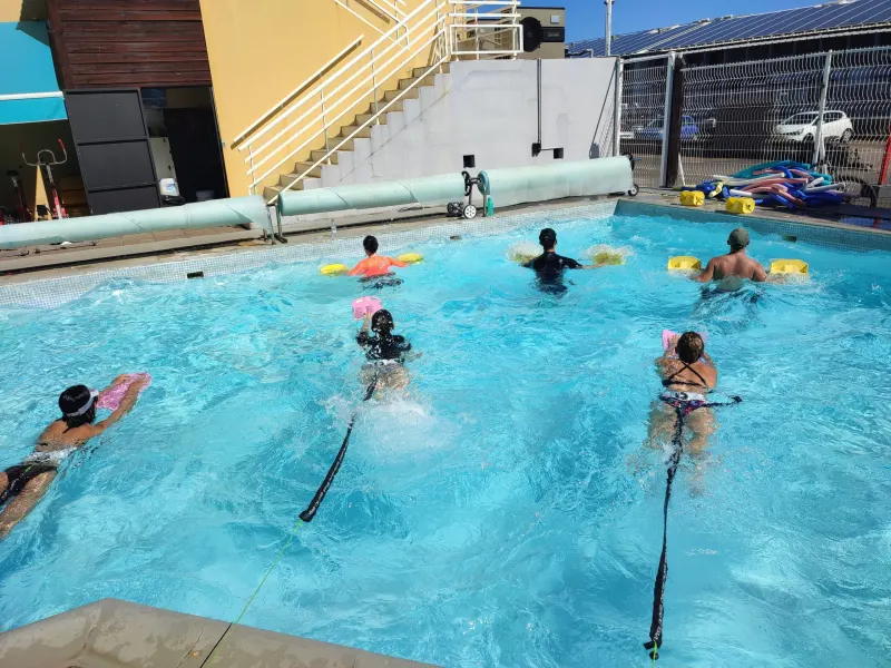 Nageurs retenus par des élastiques pendant un cours de Static Swim chez Aqua Forme