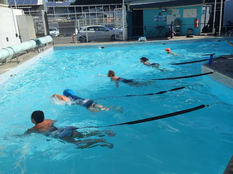 Nageur en Static Swim, retenu par un élastique dans le bassin d’Aqua Forme