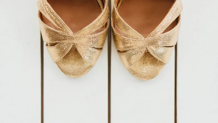 Chaussures dorées de la mariée posées au sol, prêtes pour la cérémonie