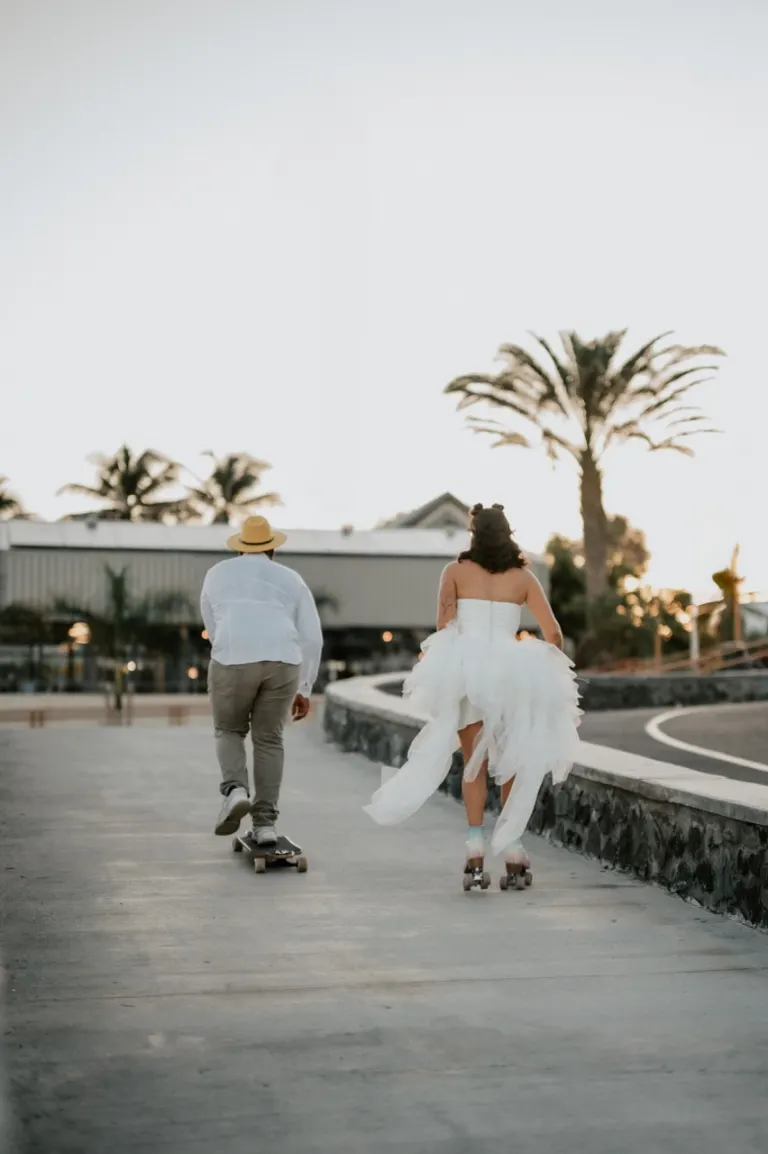 Mariés en skate et en rollers sur une promenade bordée de palmiers