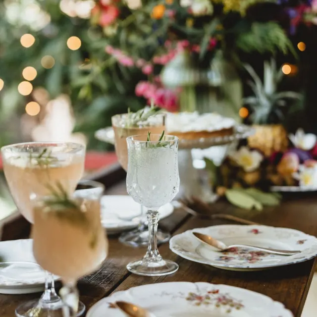 Table de réception dressée avec cocktails et fleurs tropicales pour un mariage