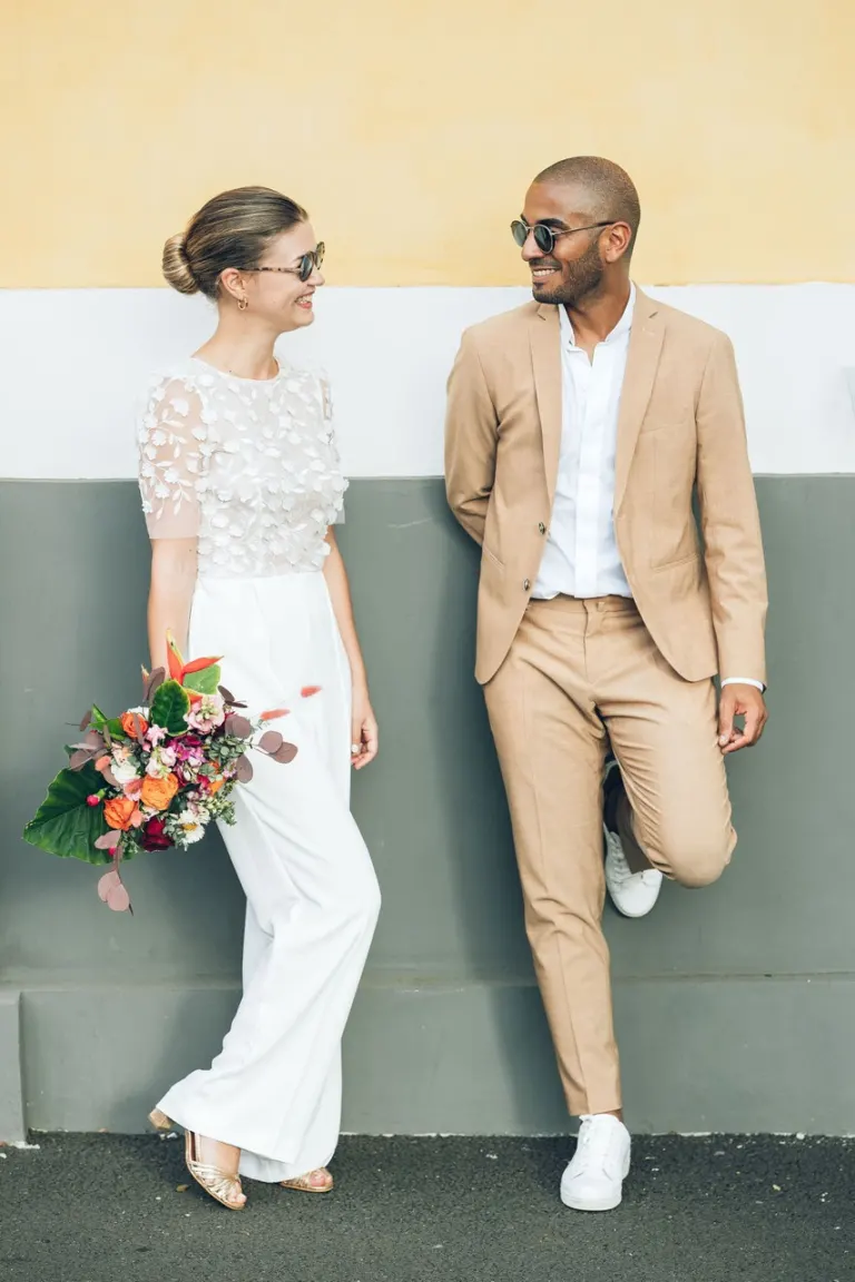 Mariés contre un mur jaune et vert, bouquet vitaminé, style créole