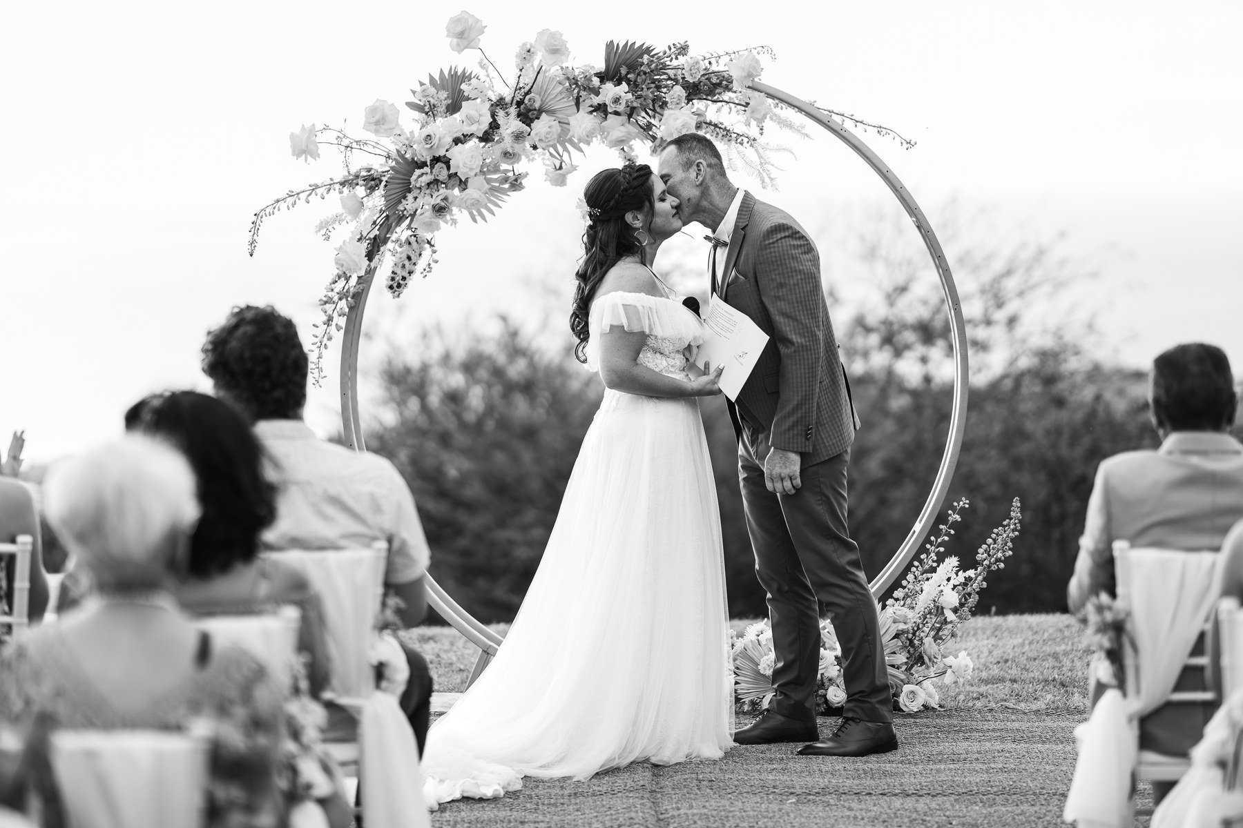 Cérémonie de mariage sous une arche ronde fleurie