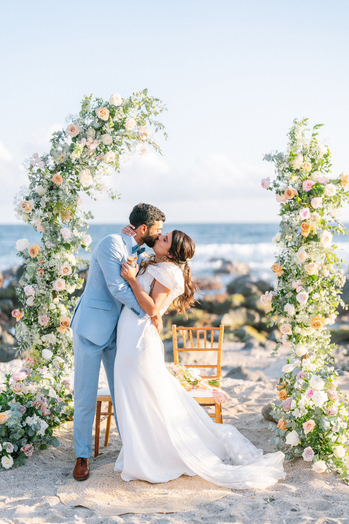 Cérémonie de mariage sous une arche fleurie face à l’océan à La Réunion