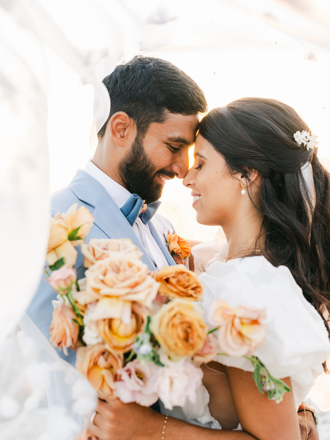 Couple de mariés et bouquet aux tons pêche
