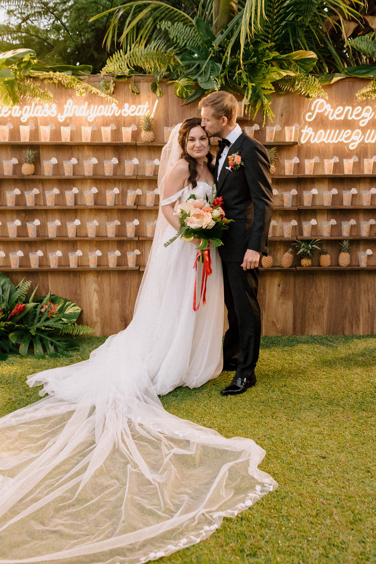 Mariée en robe à traîne devant un décor végétal
