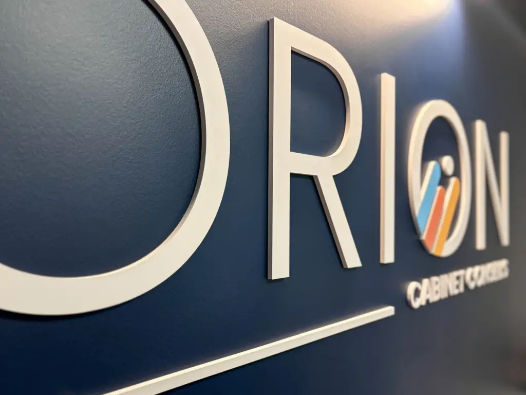 Logo Orion en relief blanc sur le mur d’accueil bleu nuit du cabinet comptable à Saint-Joseph
