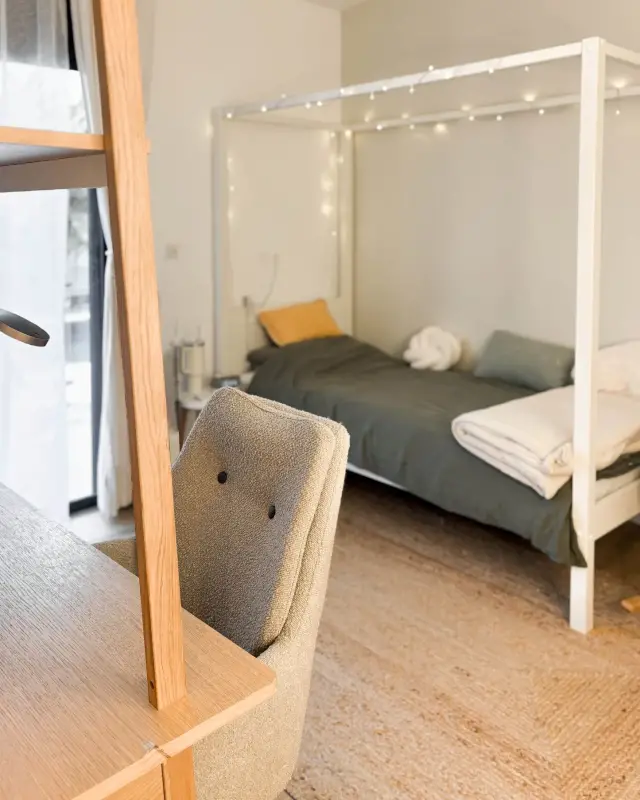 Chambre d’ado agencée à Saint-Pierre avec lit cabane blanc à guirlande lumineuse, parure kaki, tapis en jute et bureau en chêne