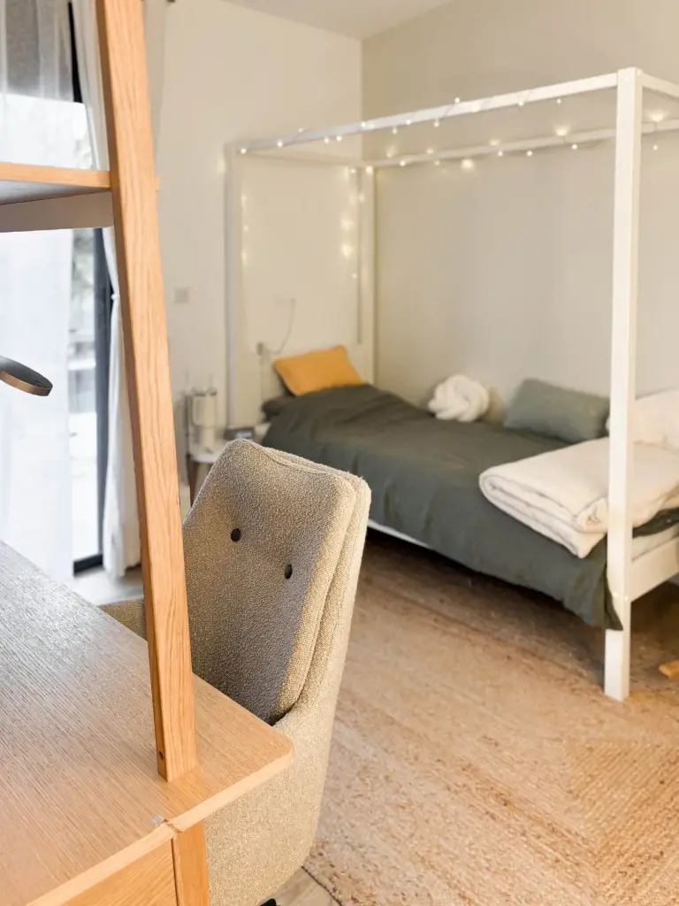Chambre d’ado agencée à Saint-Pierre avec lit cabane blanc à guirlande lumineuse, parure kaki, tapis en jute et bureau en chêne
