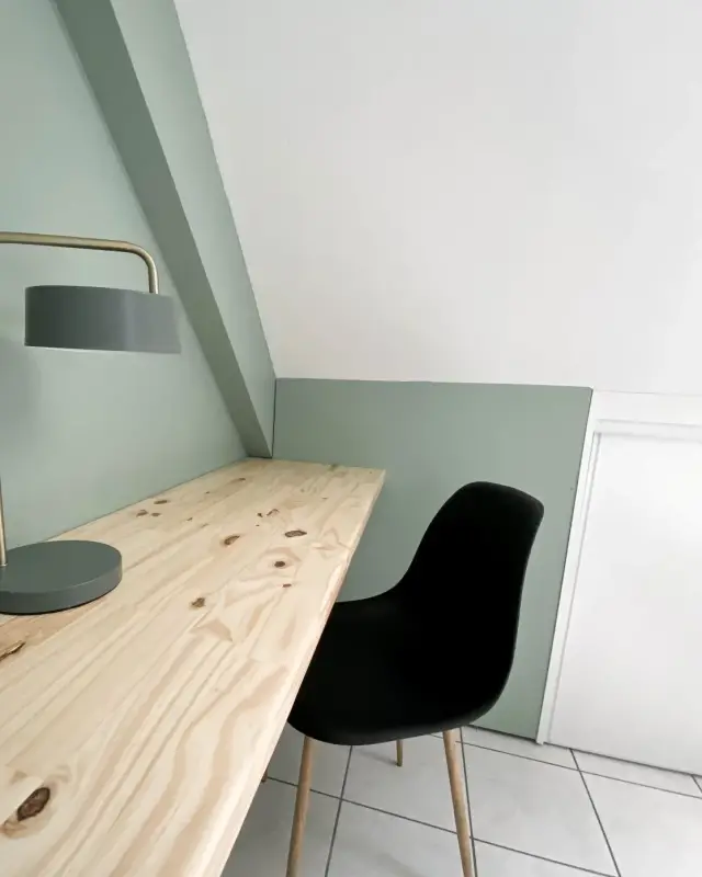 Bureau en pin massif sous rampant, aplat de peinture vert sauge suivant la pente et lampe vert-gris