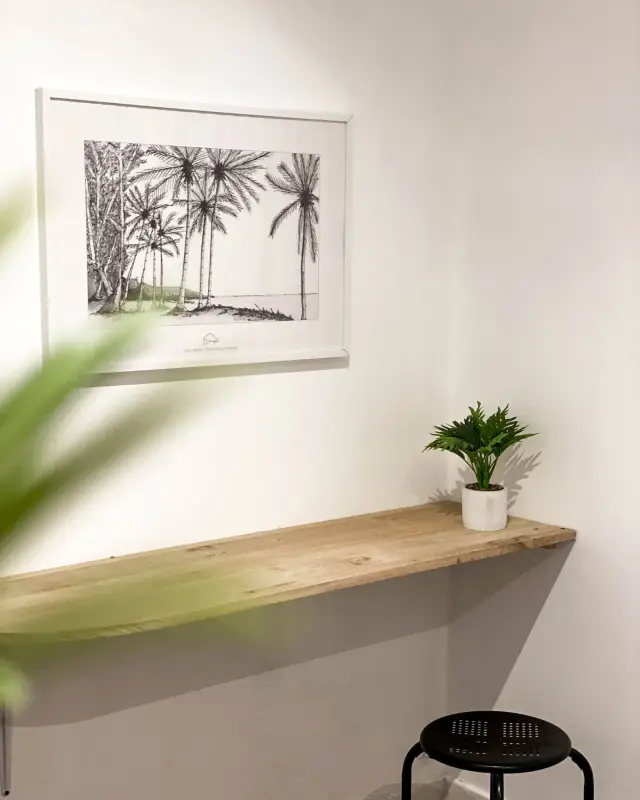 Console en bois brut et affiche Décocotier de palmiers dessinés au trait dans un cadre blanc