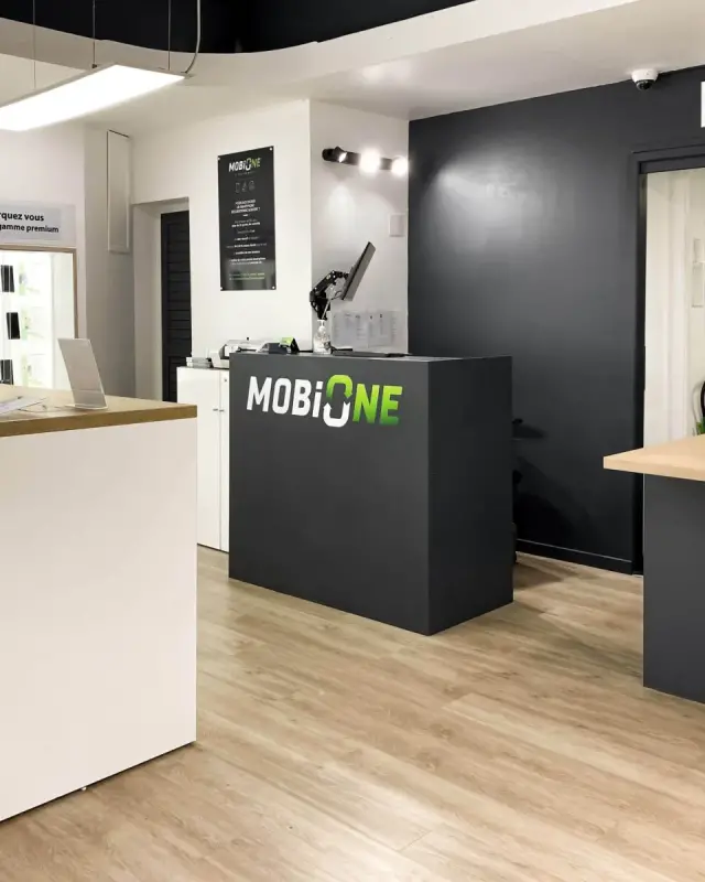 Comptoir de caisse anthracite au logo MobiOne et comptoir de service après-vente avec tablette en chêne