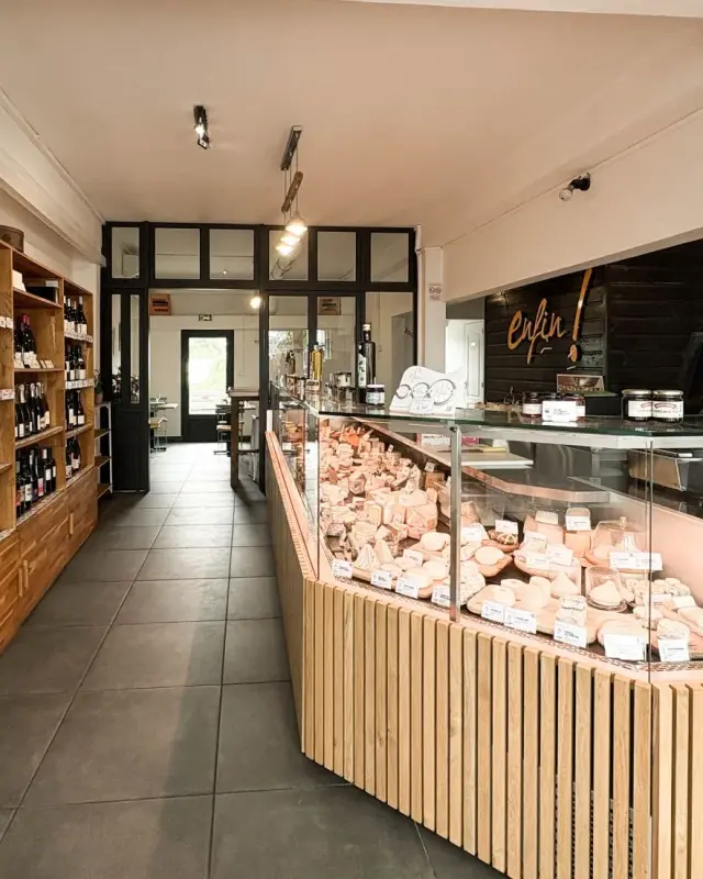 Comptoir de fromages en tasseaux de chêne et caisse devant un mur en lames noires au logo enfin !