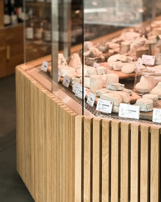 Détail de la vitrine de fromages habillée de tasseaux de chêne massif verticaux