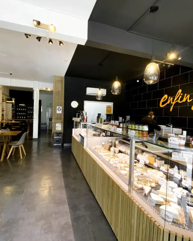 Meuble à vins en bois sur roulettes et vue vers l’espace de dégustation au fond de la boutique