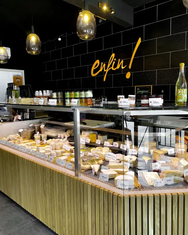 Vitrine de fromages en angle avec habillage en tasseaux de chêne et ardoise d’accueil