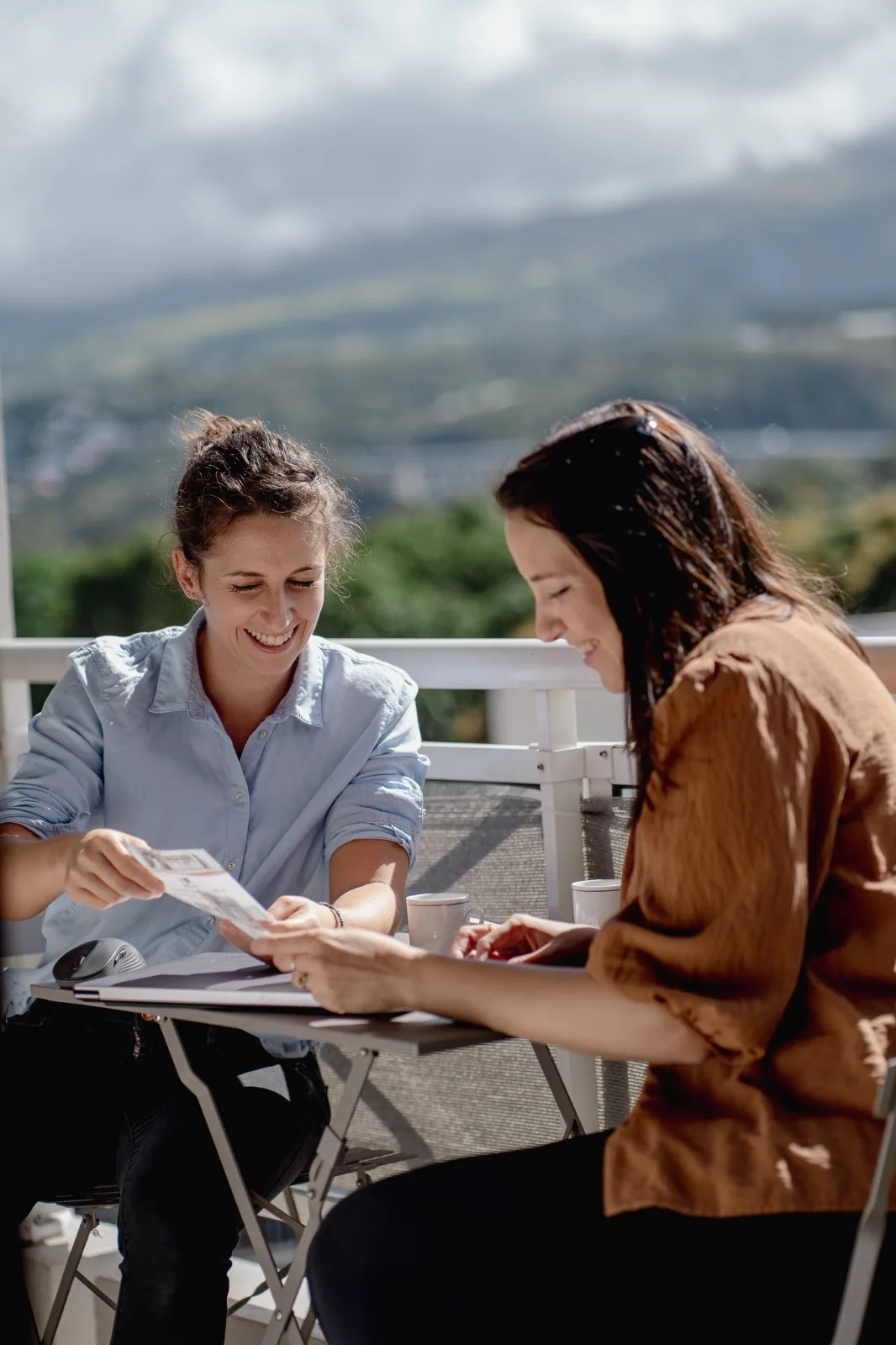 Hermine et Amanda, fondatrices de Décogité, étudient des plans sur une terrasse avec vue sur les montagnes de La Réunion