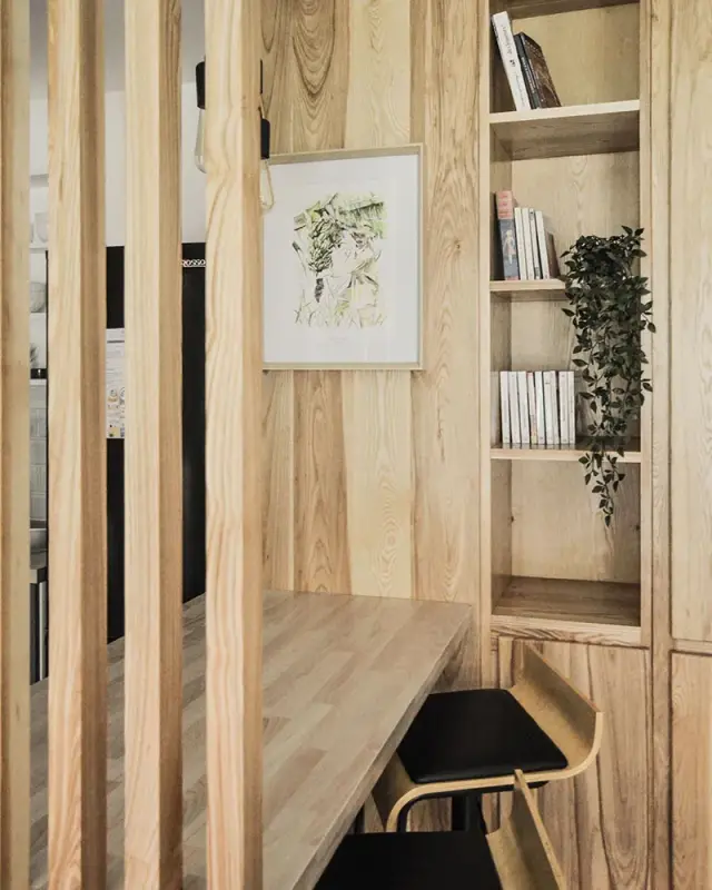 Plan en bois intégré aux rangements, tabourets en bois courbé et claustra en tasseaux