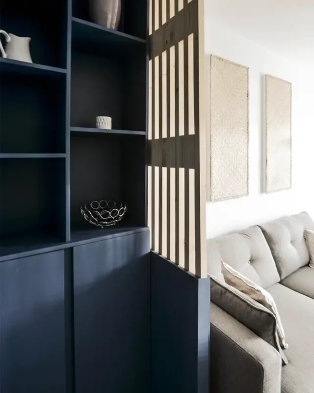 Niches bleu nuit avec objets décoratifs et claustra en tasseaux de bois clair