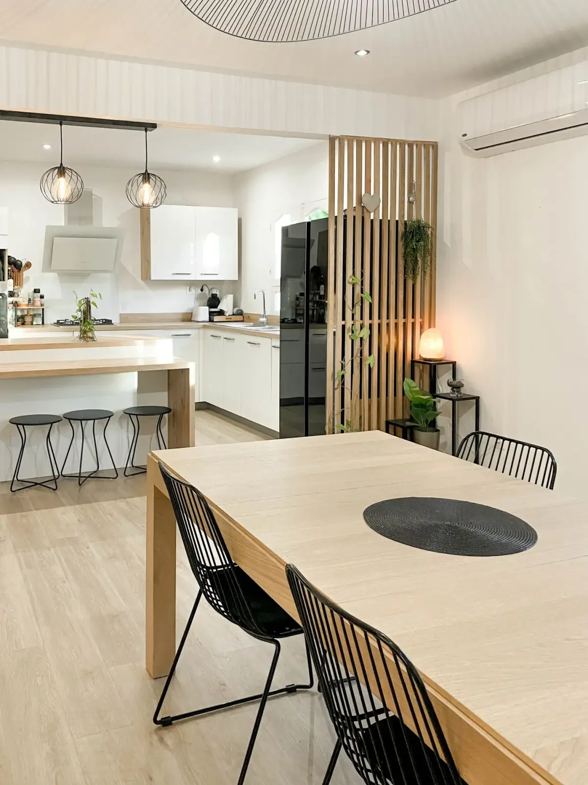 Cuisine ouverte et grande table en bois clair d’une maison familiale rénovée à Saint-Pierre