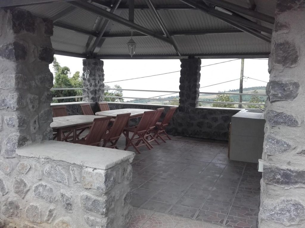 La grande table et les chaises sous le kiosque en pierre