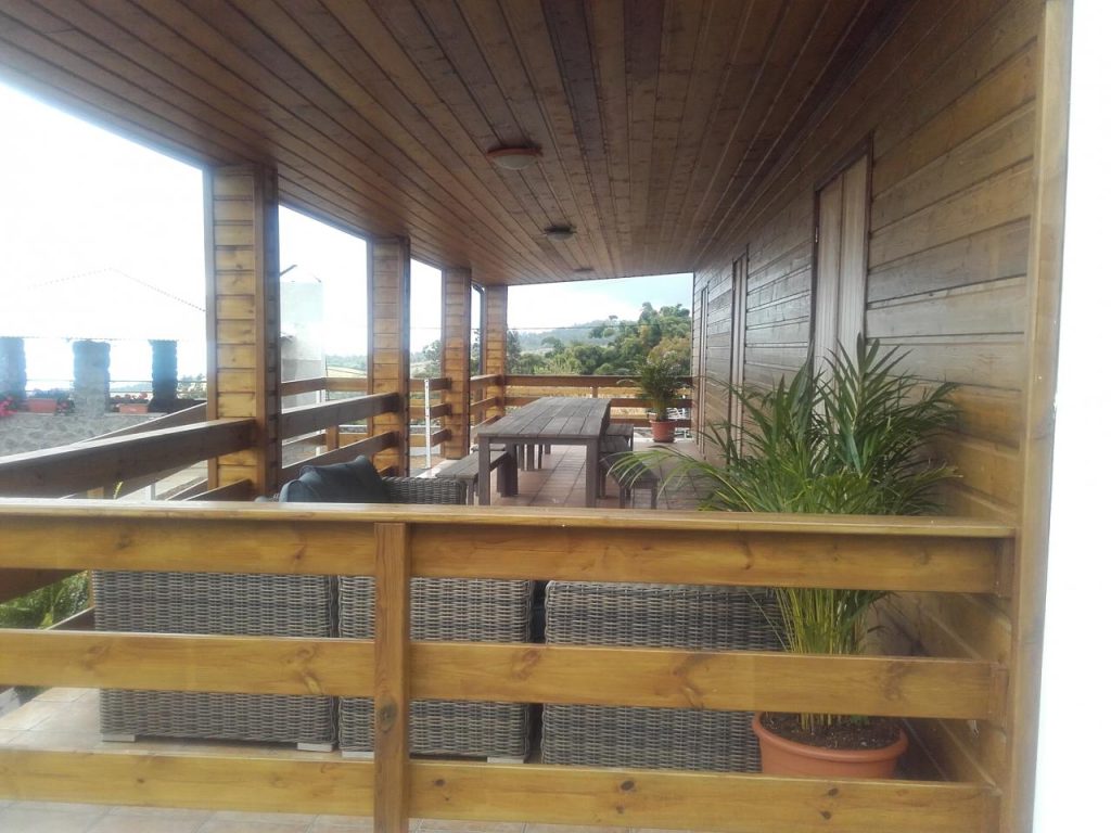 La varangue de l'étage, terrasse couverte en bois avec sa grande table