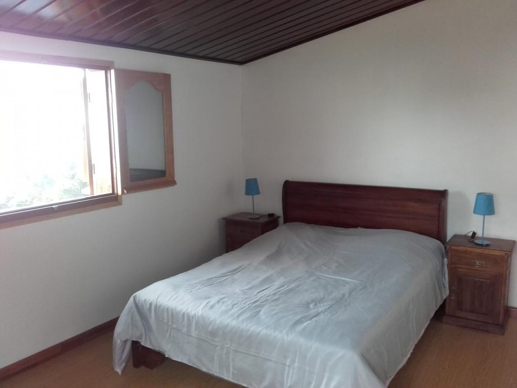 Chambre double lumineuse avec plafond en bois et mobilier en bois massif