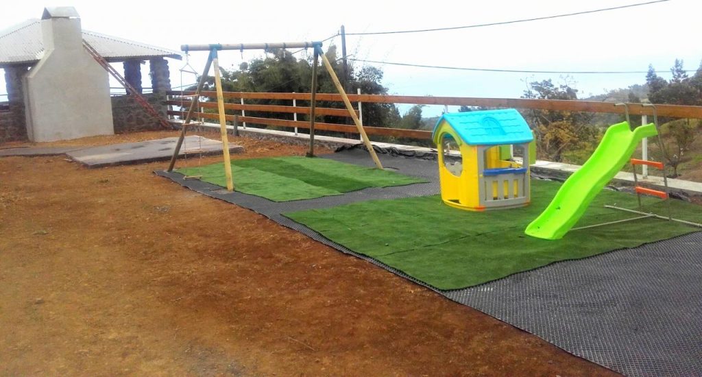 L'aire de jeux des enfants : balançoires, toboggan et cabane