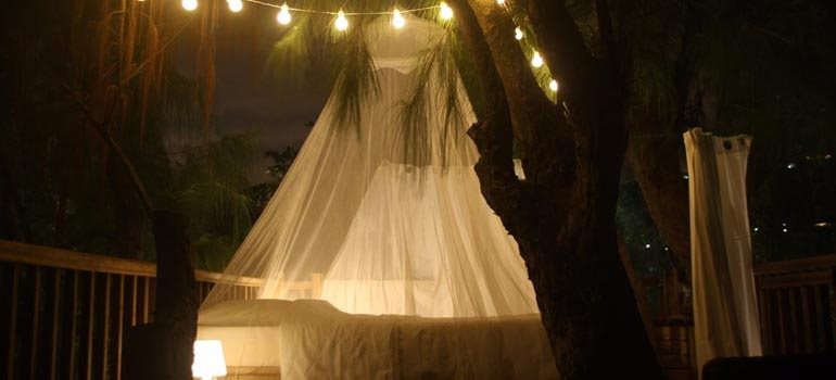 Chambre éphémère éclairée par une guirlande lumineuse sur la terrasse en hauteur