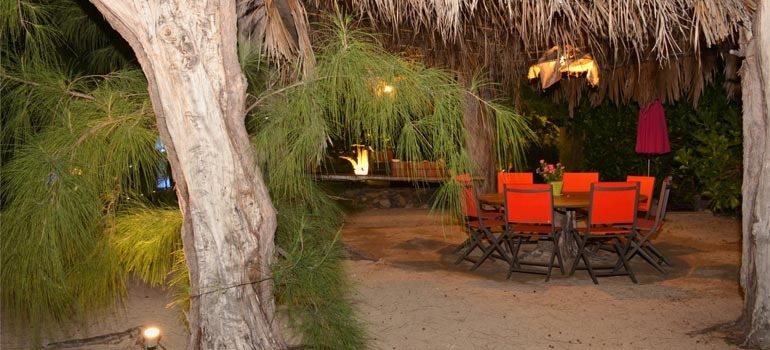 Tonnelle en feuilles de cocotiers éclairée le soir au milieu des filaos