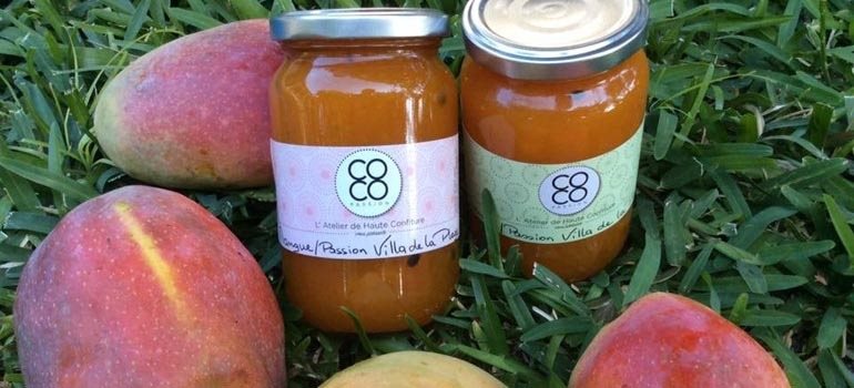 Confitures COCO Passion posées au milieu de mangues