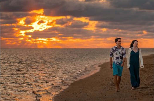 Couple se promenant au bord du lagon au coucher du soleil
