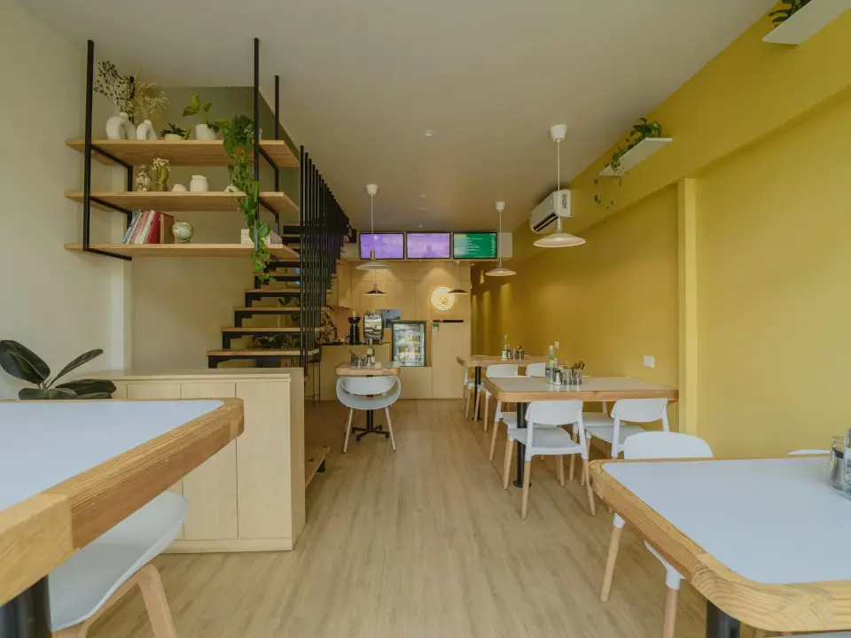 Salle du Palma Café, tables en bois et étagères de céramiques