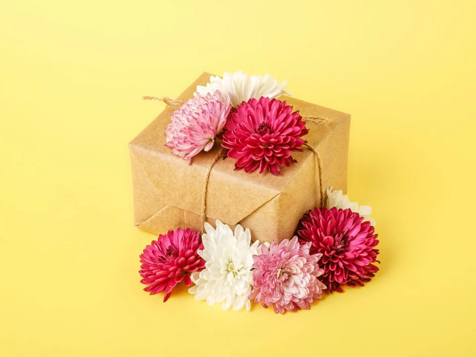 Cadeau emballé de papier kraft et de fleurs roses, carte cadeau pour un atelier céramique